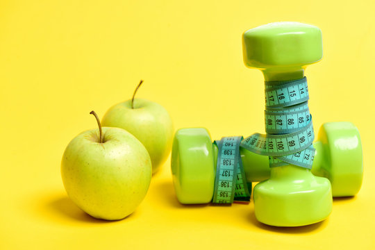 Pair Of Fresh Apples Near Green Dumbbells Wrapped With Tape