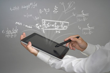 Man scientist or student holding tablet PC and working with various high school maths and science formulas.