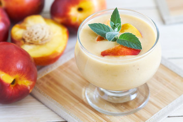 Nectarine smoothie with yogurt served with mint leaves and fresh nectarines