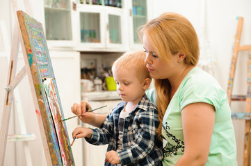 Obraz premium Mother and child draw a picture paints, art lesson