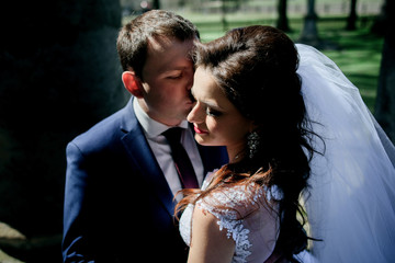Sunlight illuminates kissing wedding couple