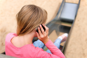 Junges Mädchen benutzt ihr Smartphone anstatt zu spielen © redaktion93