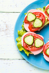 Bruschetta with salad, sausage, tomato and cucumber