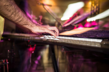 Fototapeta na wymiar Musician plays keyboards in a rock band