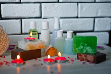 Bathroom accessories. Body care. Multi-colored natural soap, gels, shampoos, balms in vials, sea salt for a bath, a bast. Bathroom, bathroom cosmetics on a light, white background. Spa treatments with