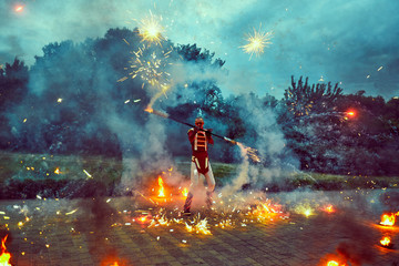 Dancing with fire in the dark on the street.