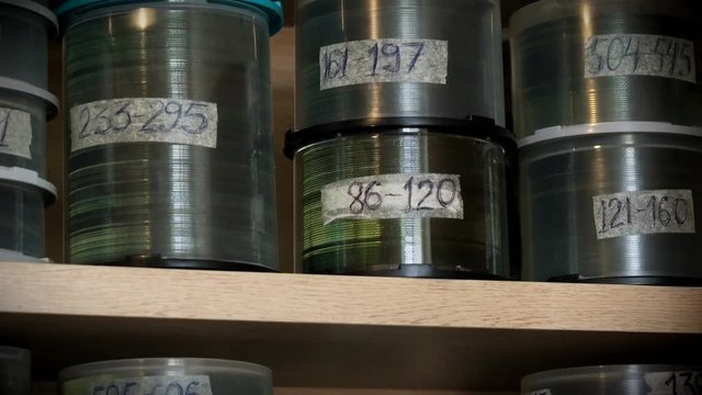 Compact Optical Dvd or cd Discs in Plastic Boxes Standing on Shelves