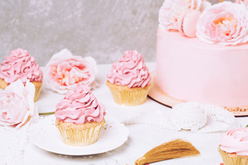 Pink cupcakes with roses and holiday cake. Festive and bright. Wedding Celebration concept.