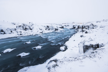 Icelandic winter wild river flowing in the canyon