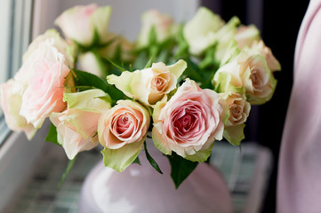 Bouquet of pink roses on the windowsill, in a pink vase. the atmosphere of coziness