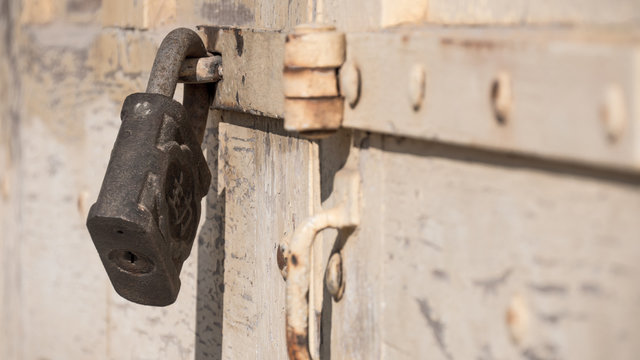 Vorh&auml;ngeschloss an einem alten kaputtem Holztor