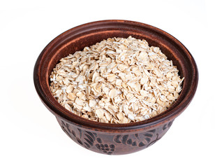 Uncooked oat flakes in brown bowl on white background. Healthy food. Closeup, copy space