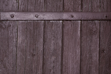 Vintage texture of painted brown old wooden gate with a metal jumper