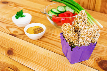 Chicken fillet in oat flakes on wooden background