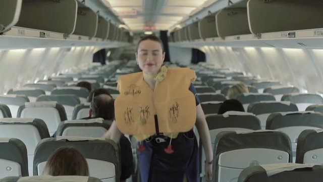 Pretty stewardess shows the safety instructions