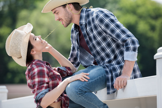 young smiling cowboy style couple flirting outdoors