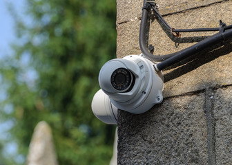 white CCTV camera on a stone wall