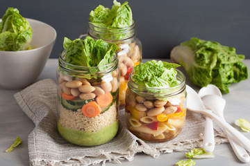 vegan couscous and pasta salad in mason jars with vegetables beans