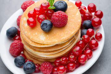 Stack of pancakes with blueberry and fresh berry.