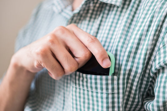 Man's Hand Holding A Smart Phone In Shirt Pocket