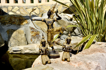 Thai Buddha with archer and two praying monks