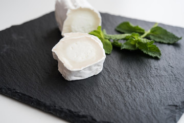 Fresh goat cheese on black plate