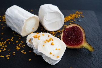 Fresh goat cheese with pollen and fig on black bacground