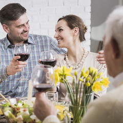 Young couple and their parents celebrating with red wine