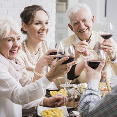 Senior parents and adult daughter toasting her promotion