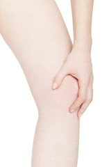 Young woman holds her hand on knee, pain isolated on white, clipping path