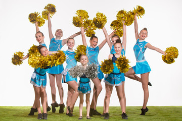 The group of teen cheerleaders posing at white studio