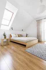 Fototapeta na wymiar Wooden bed in cozy bedroom