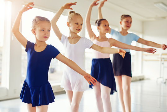 Group of cute girls standing and practicing ballet