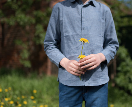 Junge hält gelbe Blume in der Hand