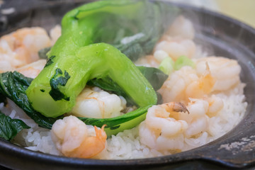 Close up of claypot rice with shrimp and chinese kale with stream