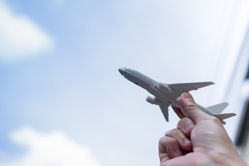 Travel concept.  Close up of man hand holding airplane toy and raise up to the sky
