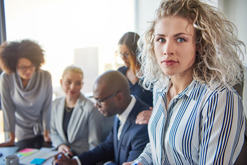 Fototapeta premium Focused young businesswoman with colleagues working in the background