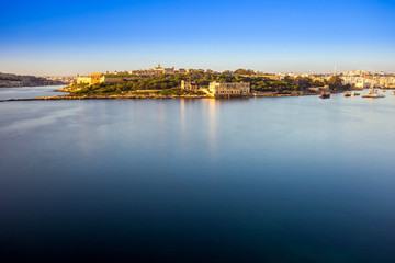 Valletta, Malta - Summer sunrise view with Manoel island, Valletta and Sliema with sailing boats and clear blue sky