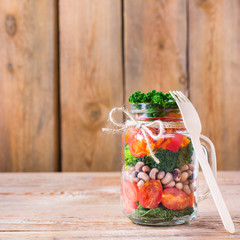 Healthy vegan salad in a mason jar with beans