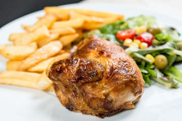 Chicken with sauce and golden French fries potatoes