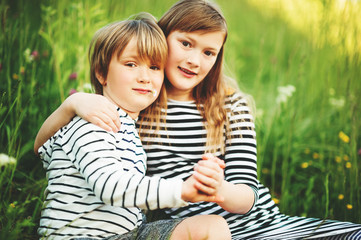 Fototapeta na wymiar Outdoor portrait of two adorable kids playing together