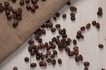 coffee beans on wooden background and rough cloth,