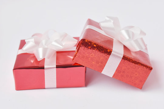 Red gift box and ribbon bow on white background. Concept for Valentine day, Christmas present and New Year.