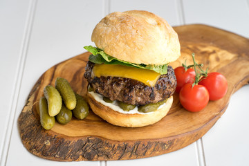 large thick grilled beef minced burger patty with toasted bun melted cheddar cheese green fresh...