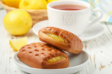 Traditionall Breakfast. Fresh homemade buns with lemon and tea. Rustic style. Selective focus