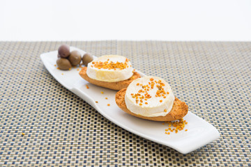  Goat cheese with honey on white plate, macro, isolated