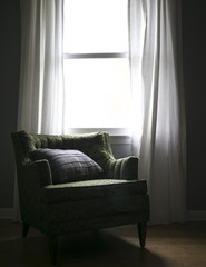 Window Light Shining on Vintage Arm Chair with Pillow