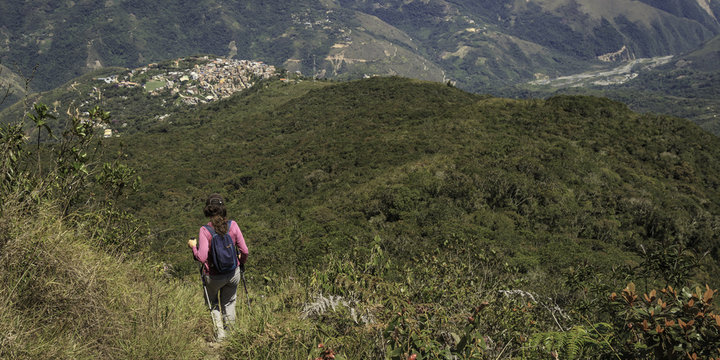 Person looking a town in middle of the mountains