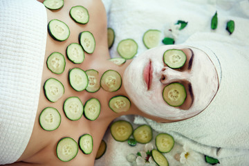 A face mask being applied to a beautiful young woman at a beauty spa