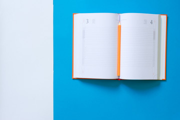 Top view blue desk table. Office tools on colored background. Flat lay of workspace